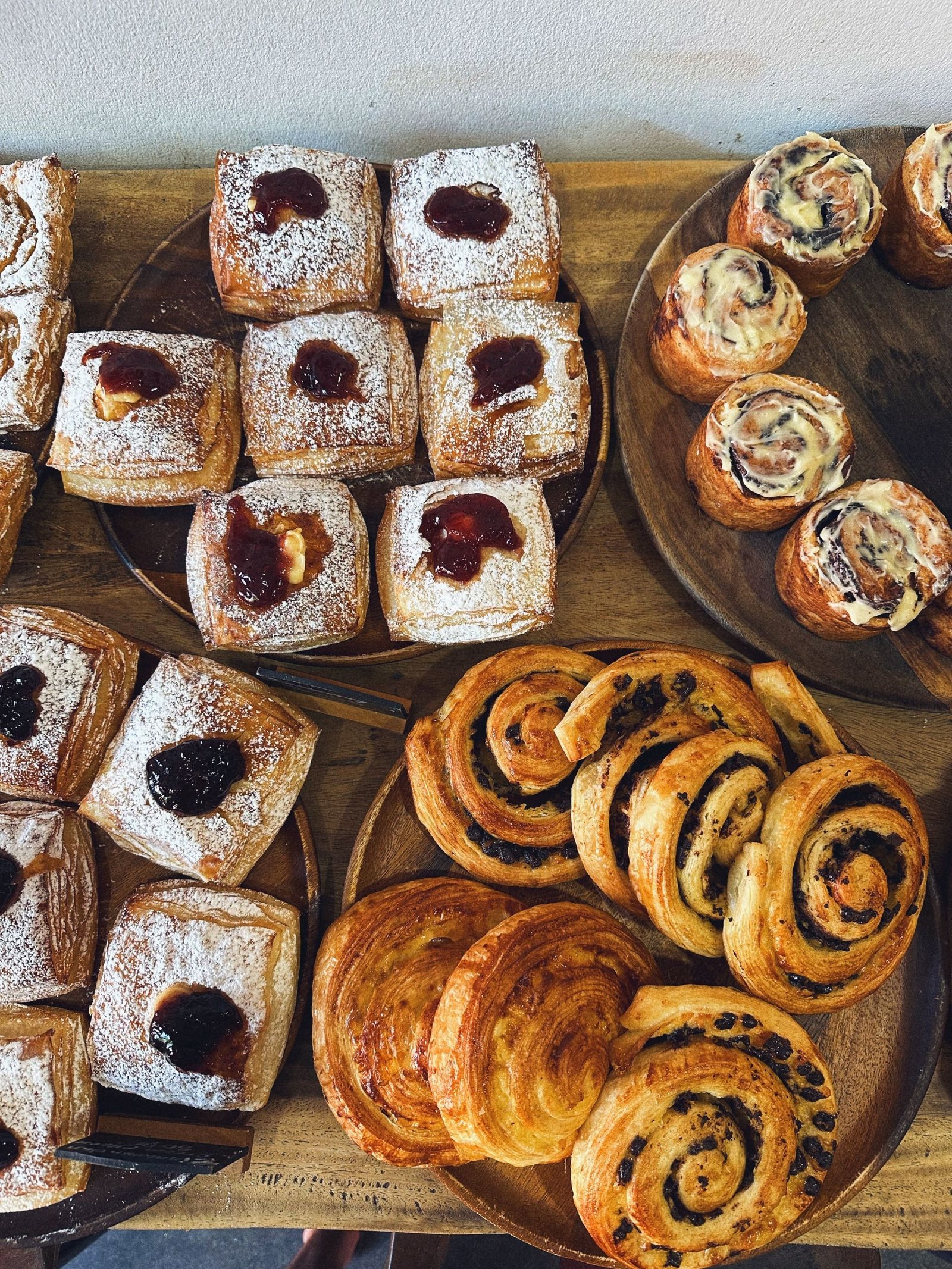 A top-down view of various fresh pastries including Danishes and buns, perfect for breakfast or dessert.